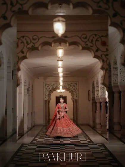 A bride, poised and radiant, in a majestic palace corridor. We specialize in creating these artistic, cinematic bridal portraits that feel like a scene from a royal epic, celebrating the grace and beauty of the moment.
