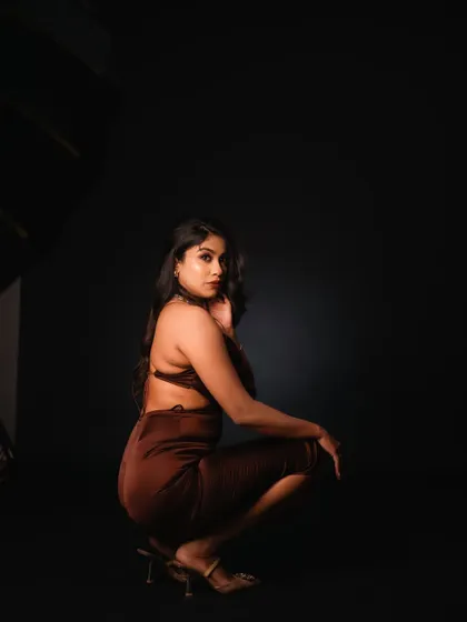 This studio portrait uses a single light source to create a dramatic, low-key effect. The shadows and the model's pose create a sense of mystery and intensity, perfect for a high-fashion editorial.