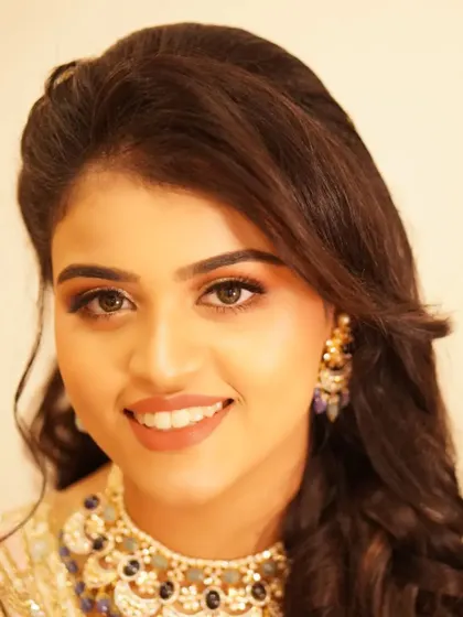 A bright, happy portrait of Payal. Her reception makeup, featuring sparkling eyes and a warm smile, is the perfect complement to her joyful demeanor.