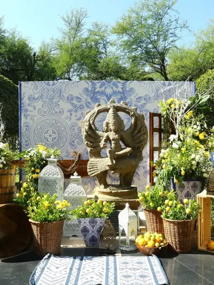 A beautiful outdoor setup at a Rajasthan wedding, blending traditional Indian decor with blue and white pottery themes.