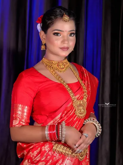 A classic portrait of the Bengali bride. The focus is on her serene expression and the intricate details of the gold jewellery.