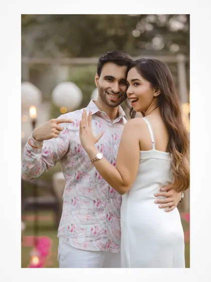 A fun shot of the couple showing off the engagement ring.