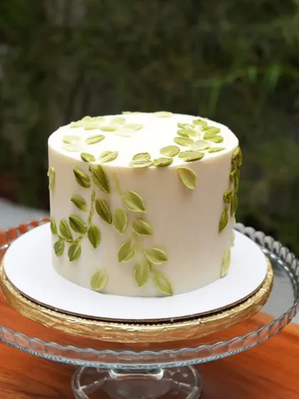 Simple, elegant, and fresh. This cake, with its hand-painted green leaves, traveled all the way to Coorg for a combined Holy Communion and Baptism. I build my cakes with a strong internal structure so they arrive picture-perfect.