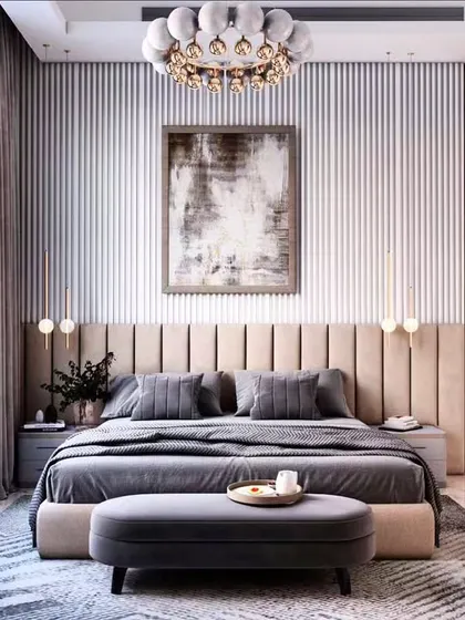 A luxurious bedroom featuring a tufted headboard against a vertically paneled wall. The elegant chandelier and soft, neutral tones create a timeless and sophisticated retreat.