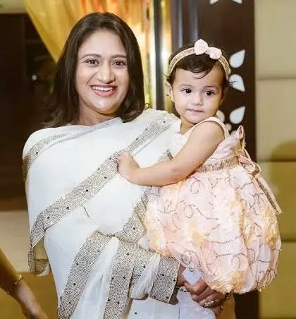 A beautiful portrait of a mother in a white saree holding her young daughter.