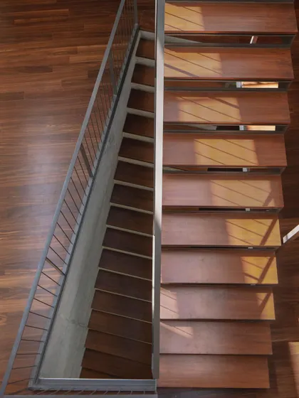 (Duplicate of 35) A top-down perspective on the wooden staircase, emphasizing the rhythmic pattern of the steps and the warm texture of the material.