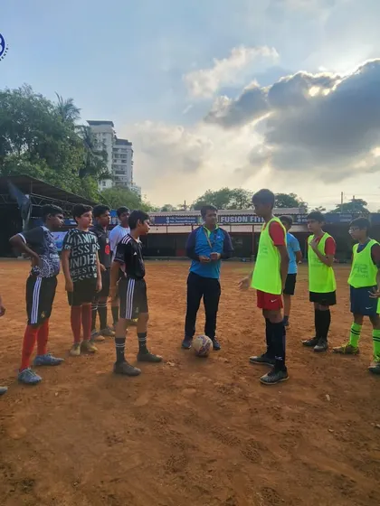 A coach gives tactical instructions to the team during a huddle. We emphasize strategy and communication to ensure our players are not just skilled, but also smart on the field.