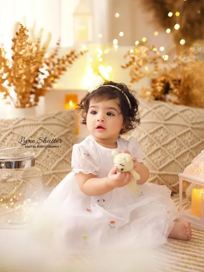 A duplicate of image 40, showing a candid moment of the birthday girl in a dreamy, light-filled setting, holding a small teddy bear.