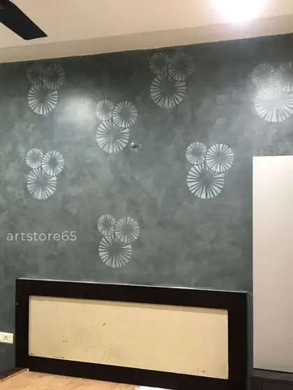This bedroom accent wall features a modern, repeating circular pattern in silver over a dark grey textured finish. It's a great way to add a contemporary design element to a room without overwhelming the space.