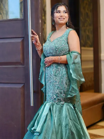 A full-length shot showing off the dramatic mermaid silhouette of her green gown.