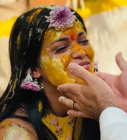 A tender moment as haldi is applied to the bride's face. These are the heartfelt, personal rituals that form the core of the celebration.