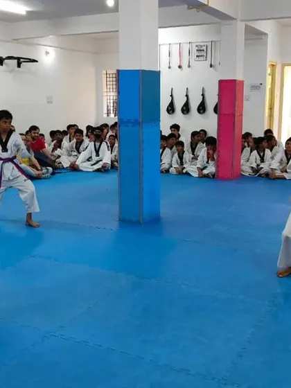 An instructor observes two students practicing.