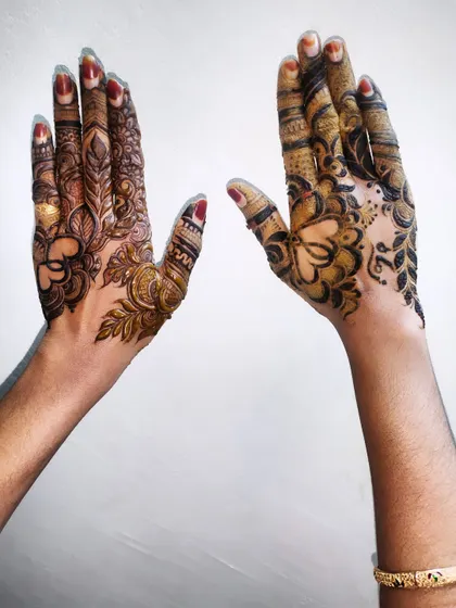 Another shot of these two distinct henna designs, one with more floral elements and the other with bolder, abstract patterns.