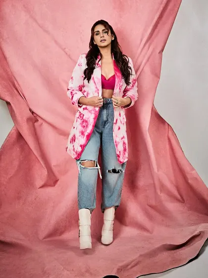 A full-length shot against a matching pink backdrop, which makes the colors of the outfit pop even more.