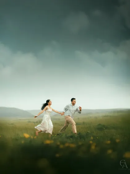 A candid shot of a couple running hand in hand through a vast, open field. This captures the energy, freedom, and pure happiness of being together.