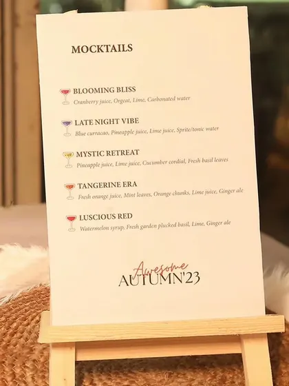 The mocktail menu for the "Awesome Autumn" event, presented on a simple easel, reflecting the event's chic and minimalist aesthetic.