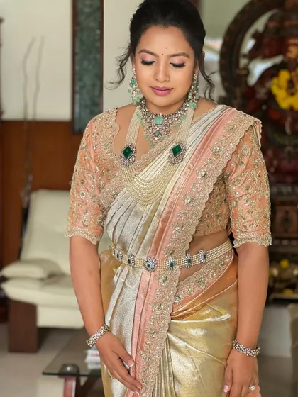 A beautiful portrait showcasing a look of quiet confidence. The makeup is flawless, with a focus on skin and soft definition, letting the stunning jewelry shine.