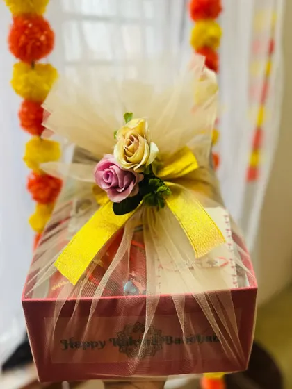 The red Rakhi gift box elegantly wrapped in tulle with a golden ribbon, ready for gifting.