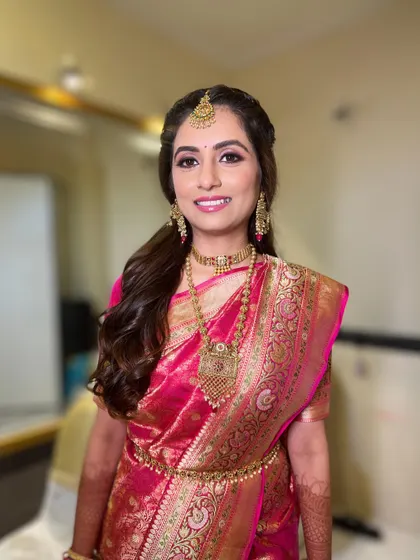 A smiling portrait of the bride, her makeup fresh and radiant for her special day.