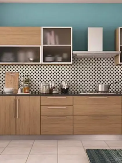 A modular kitchen with a unique color palette, combining wood-finish cabinets with a teal accent wall. The black and white patterned backsplash adds a retro, graphic element to the space.