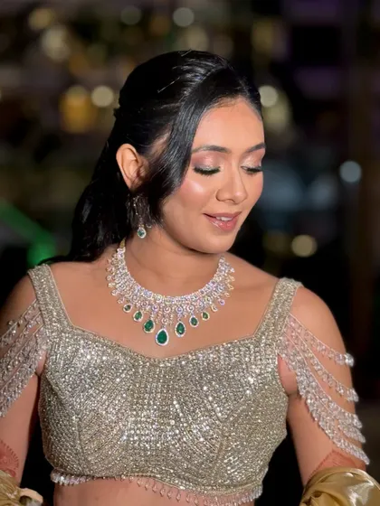 A close-up of a royal sangeet look, featuring soft smokey eyes and a diamond and emerald necklace.