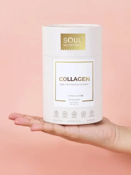 A simple, elegant shot of the collagen supplement held in a palm. The soft pink background and clean composition give the product a gentle, wellness oriented feel.