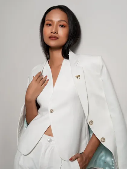 An elegant and clean shot of a white power suit. The lighting is bright and even, perfect for a commercial lookbook.
