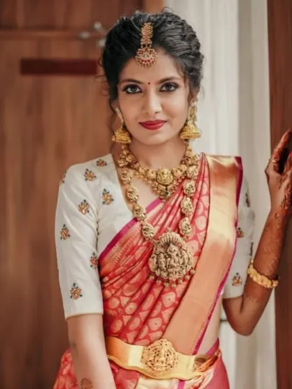 A portrait of the bride, highlighting her traditional jewelry and the simple elegance of her white embroidered blouse.