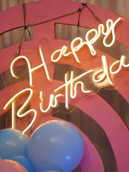 A close-up of a custom 'Happy Birthday' neon sign. This is a popular add-on that serves as a perfect photo opportunity and centerpiece for any celebration.