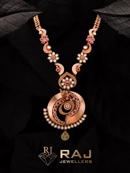 Unleash your inner goddess with this exquisite Revaj necklace. The unique spiral pendant is a work of art, combining floral motifs, red stones, and pearls in a design that is both bold and intricately detailed.