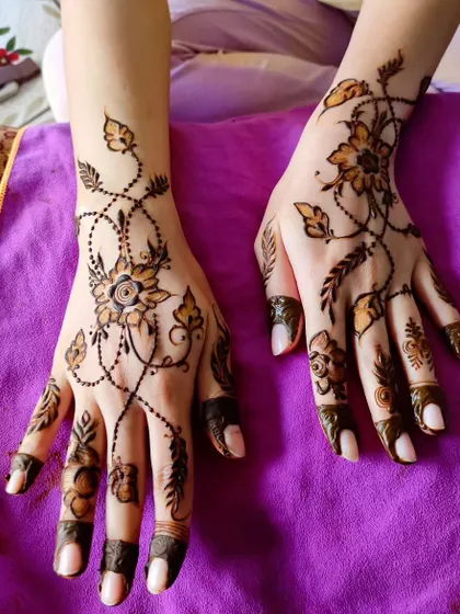 A beautiful "bail" or vine design that crisscrosses the hands, a popular choice for party henna.