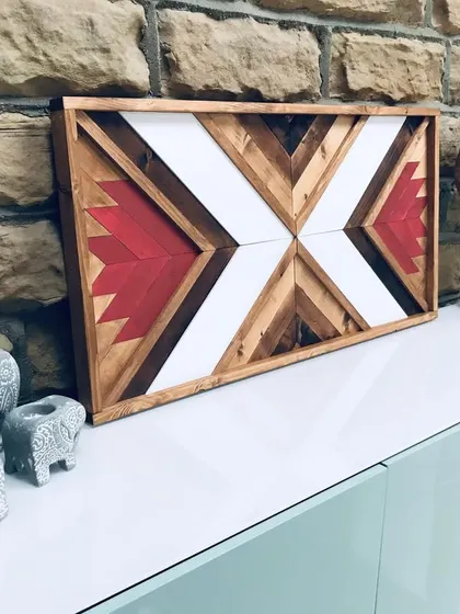 Another lifestyle shot of the Aztec wood art, paired with decorative elephants and a wooden sculpture, creating a cohesive, globally-inspired vignette.
