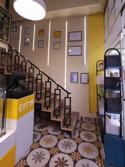 The staircase at Ditya Bakehouse features a custom-designed railing and is set against a wall with vertical light strips. This detail adds a modern touch to the otherwise warm and rustic design.