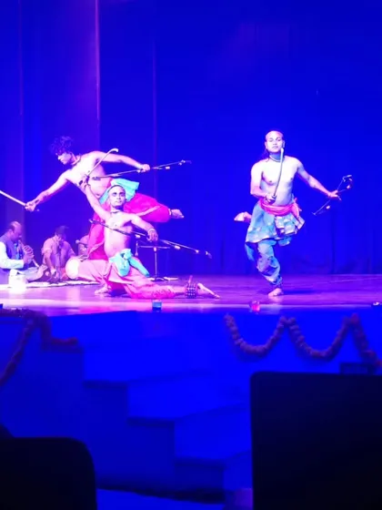 An action sequence from a Chhau performance at a SPIC MACAY event, showing dancers in mid-air with swords.