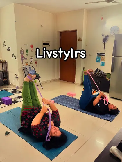 Two clients use yoga straps for a reclined leg stretch, a great way to improve hamstring flexibility and release lower back tension.