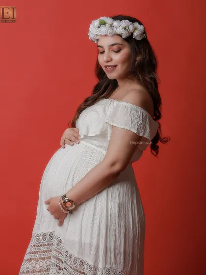 A simple and sweet off-the-shoulder white dress paired with a flower crown for a bohemian-inspired studio look.