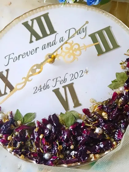 A duplicate of image 93, this preservation clock features the phrase "Forever and a Day" and a beautiful arrangement of deep purple flowers.