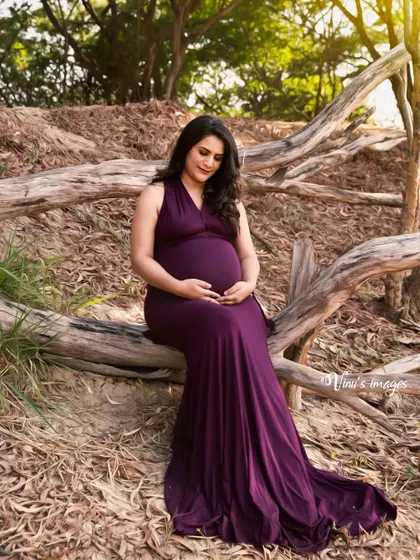 A slightly different angle of the same peaceful pose, capturing the mother's gentle expression as she cradles her bump.