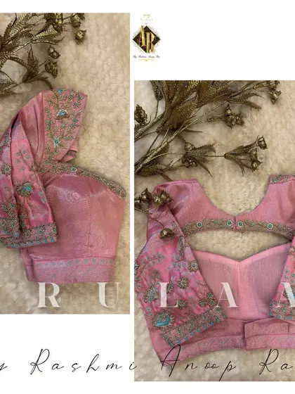A lovely pastel pink blouse with multi-color floral embroidery. The back features a keyhole cutout, and the sleeves have a beautiful, detailed design.