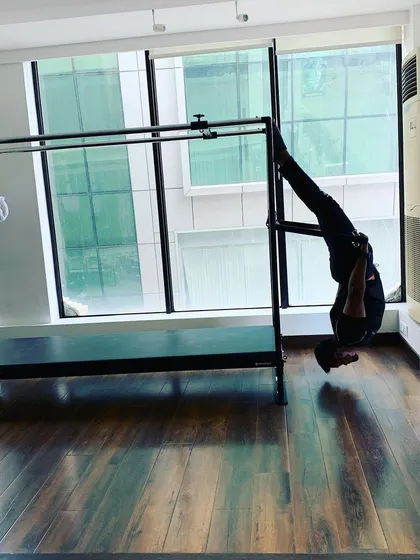 A dynamic inverted movement that showcases the power and control developed through consistent Pilates practice.