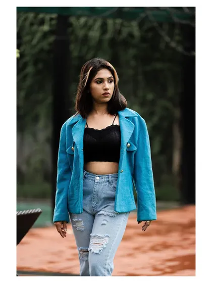 An outdoor fashion shot with a cool, urban vibe. The model's confident stance and stylish outfit create a modern and edgy look.