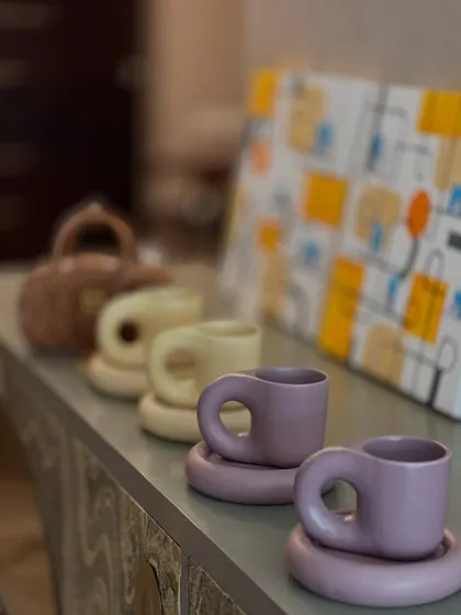 A lineup of my 'THICC' cups in pastel yellow and lilac. The chunky handle and saucer give them a playful, sculptural quality.