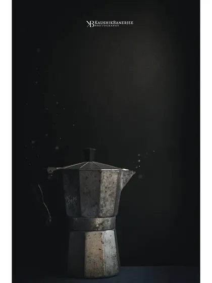 I'm drawn to negative space and minimalism. Here, a single rustic coffee maker is spotlit against a dark, textured background. The floating particles add a bit of magic to this simple, moody composition.