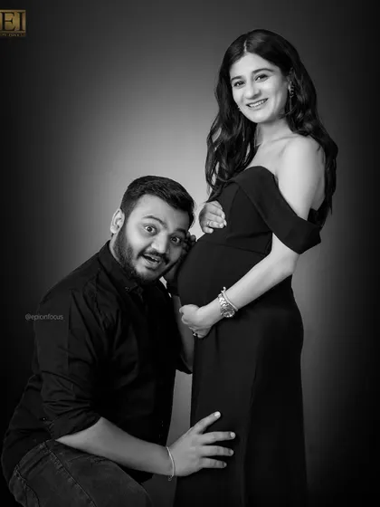 A playful and joyous moment captured in black and white. The dad-to-be's excited expression as he listens to the bump is priceless.