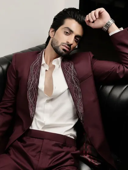The relaxed yet sophisticated styling of our burgundy statement tuxedo. The open-collar look showcases the detailed lapel, making it perfect for a modern cocktail event.