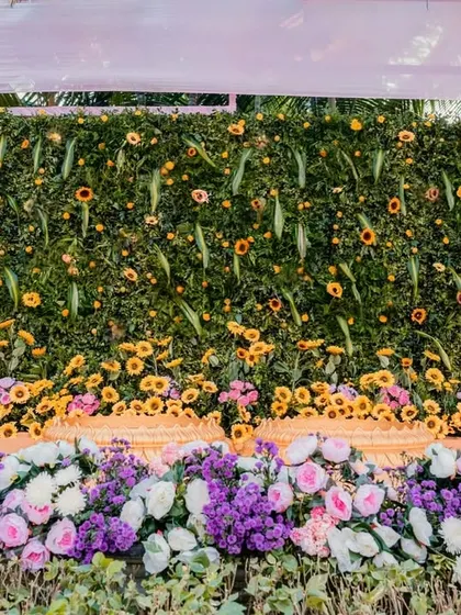 A lush green floral wall serves as a stunning backdrop for the Haldi ceremony. I use a mix of sunflowers, roses, and other seasonal blooms to create a rich, textured, and vibrant photo opportunity.