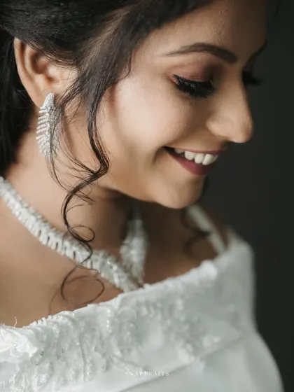 A close-up of a Christian bride's joyful smile, highlighting her delicate features and elegant jewelry.