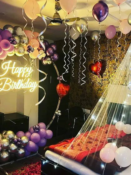A closer look at the bed area, featuring the fairy light canopy and balloons. This angle shows how the elements come together to create a cozy and special atmosphere.