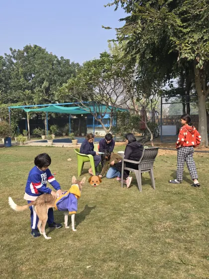 A wider view of a family enjoying a picnic-style day out. Children and pets can play safely on the lawn while the adults relax and supervise from nearby.
