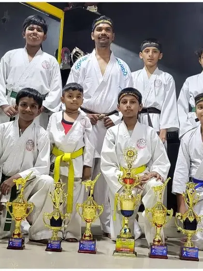The winning team from the 6th GKA Open National Karate Championship 2023, posing with our impressive collection of trophies in the dojo.